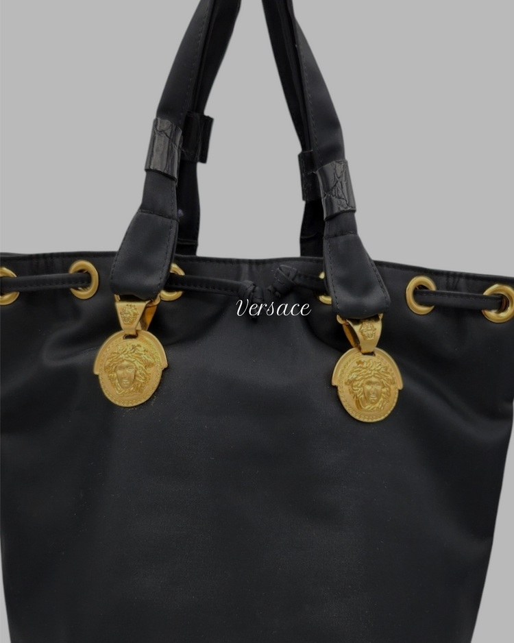 Schwarze Tasche von Versace mit goldenem Logo aus Metall